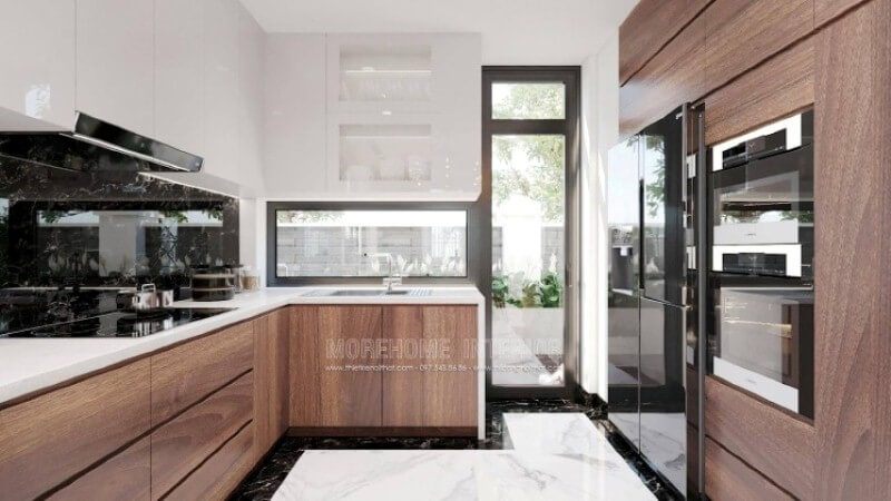 Là một trong những xu hướng thiết kế nội thất ấn tượng trong những năm tới, thiết kế phòng bếp hiện đại tôn lên vẻ đẹp mộc mạc nhưng không kém phần sang trọng của gỗ điển hình là gỗ óc chó veneer . Loại gỗ rất được ưa chuộng trong các siêu xe bởi vẻ đẹp ấn tượng từ vân, màu gỗ. Như trong ý tưởng trang trí phòng bếp tại biệt thự Vinhomes Imperia Hải Phòng, sự hài hòa tôn lên nét đẹp giữa truyền thống và hiện đại, tủ bếp dưới gỗ óc chó và tủ bếp trên gỗ công nghiệp trắng bóng.